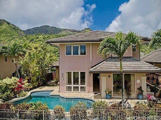Backyard pool with Koko Head ridgeline rising behind the house