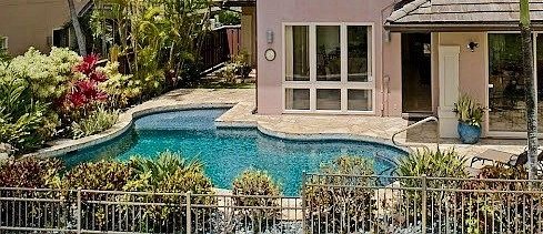 Pool waterline with travertine deck and tropical landscaping